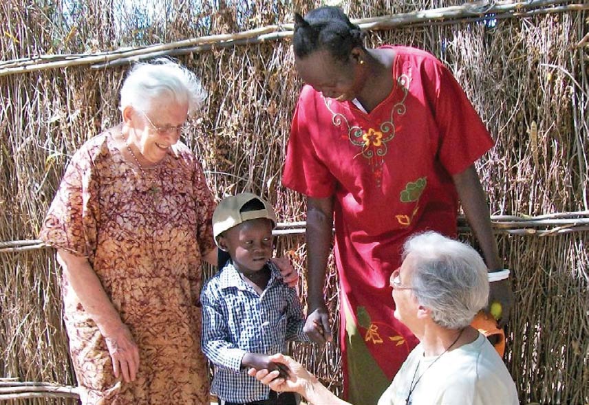 Sister Theresa and Sister Madeline greeting a Sudanese mother and child.